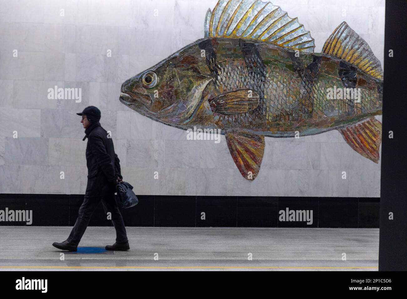 Moscow, Russia. 3rd of March, 2023. A man walks past a fish mural at