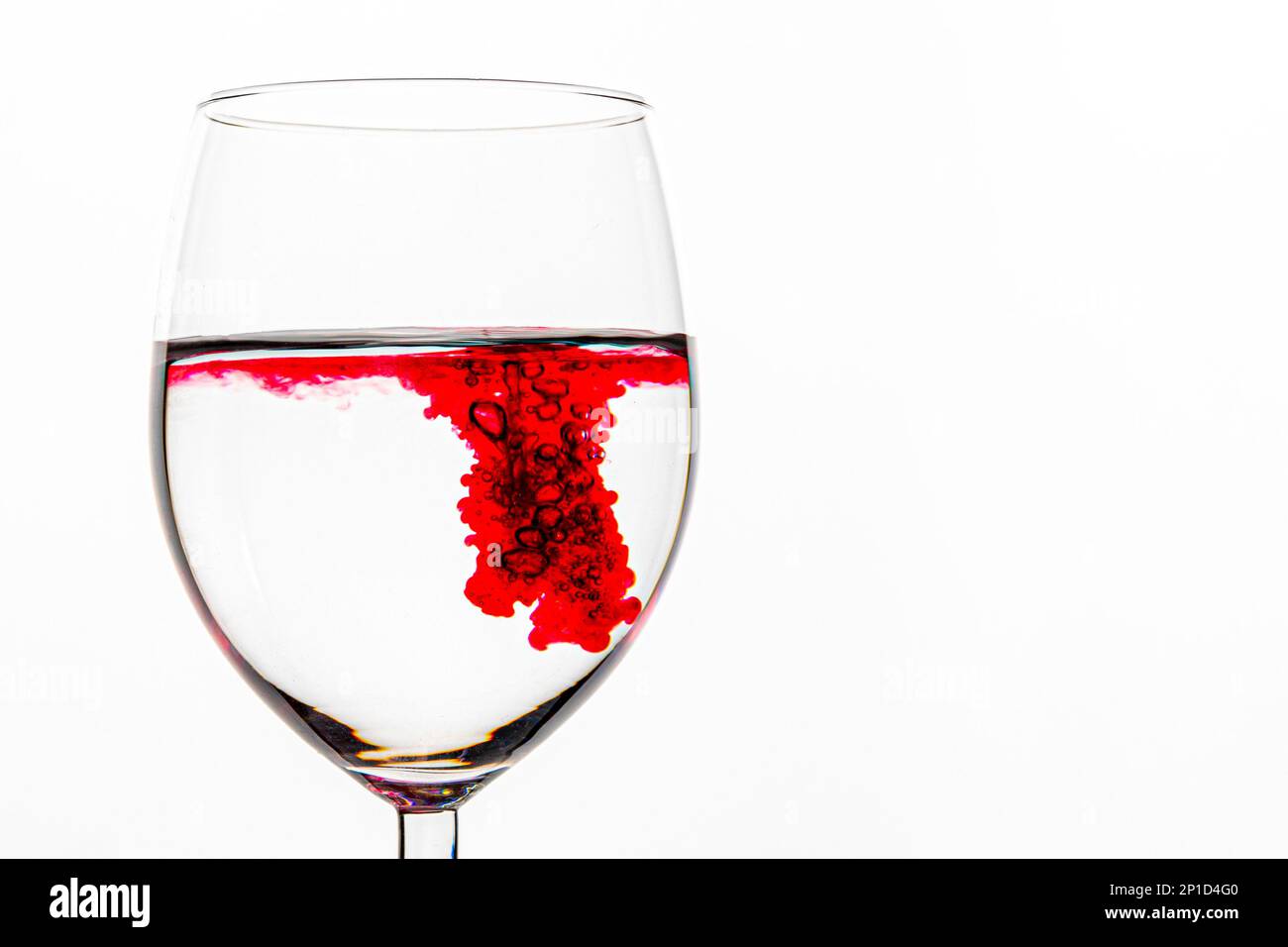 Red swirling liquid in a transparent glass cup Stock Photo