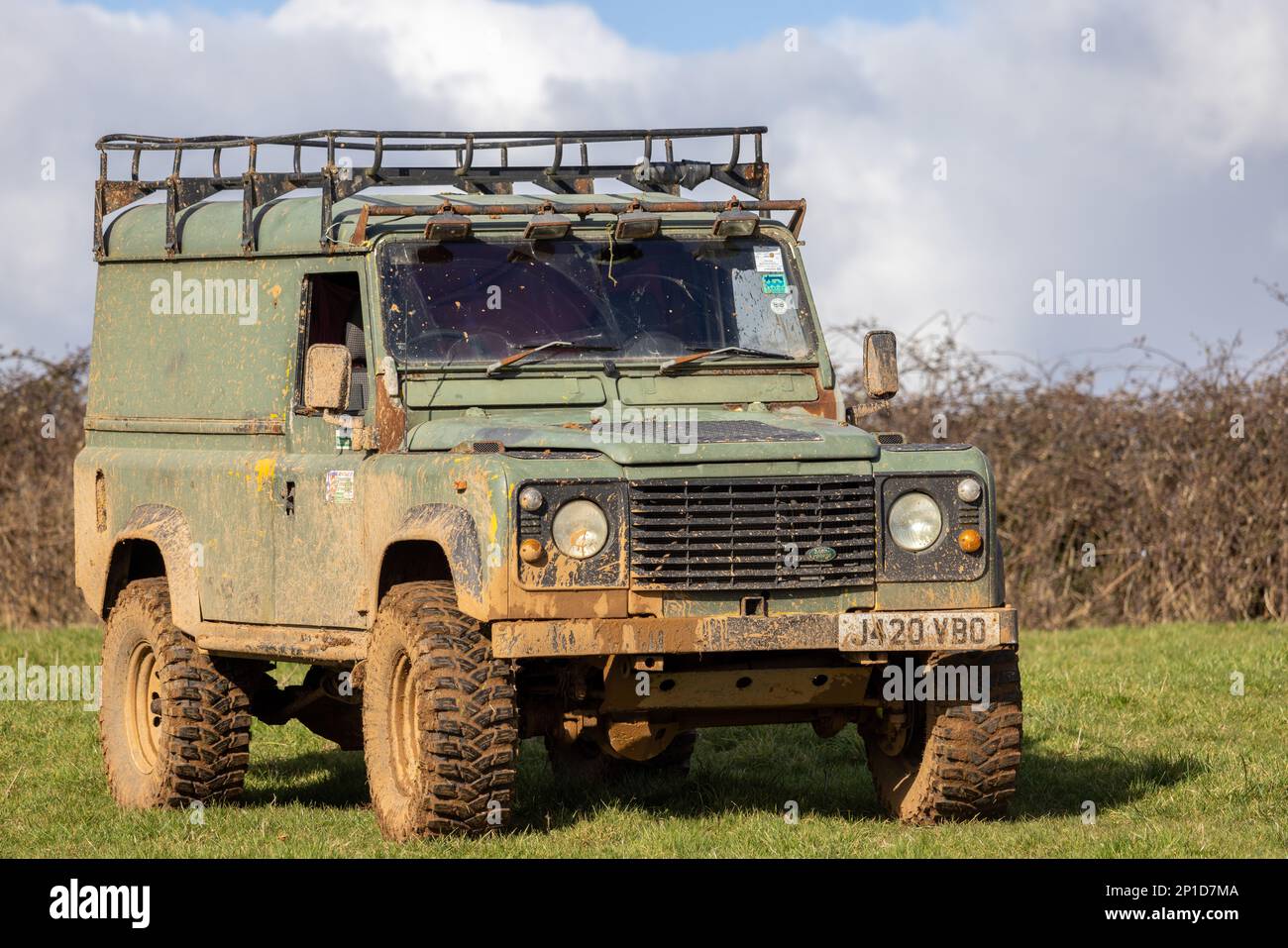 February 2023 - Ex military Land Rover Defender 110 taking part in an ADWC off road trial at Chewton Mendip in Somerset, UK. Stock Photo