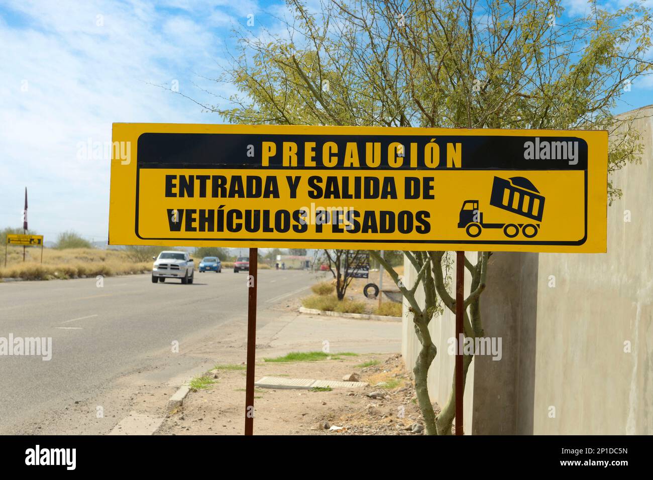Caution entry and exit of heavy vehicles sign in Spanish, seen in