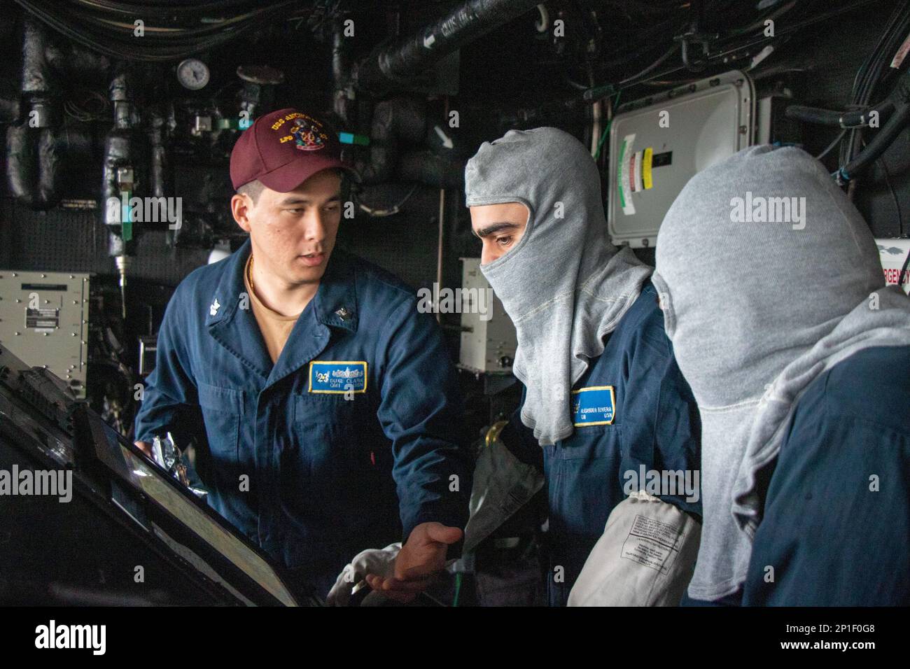 SINGAPORE (Feb. 20, 2023) – Quartermaster 1st Class Duke Clark, left, trains Quartermaster Seaman Alexander Rivera, center, and Quartermaster 3rd Class Lance Limbo on how to troubleshoot the Voyage Management System (VMS) after a GPS denial or spoofing attempt during a general quarters drill aboard amphibious transport dock USS Anchorage (LPD 23), Feb. 20, 2023. General quarters is a ship-wide alert for all hands to go to the positions they are to assume during combat or damage repair. The Makin Island Amphibious Ready Group, comprised of amphibious assault ship USS Makin Island (LHD 8) and am Stock Photo