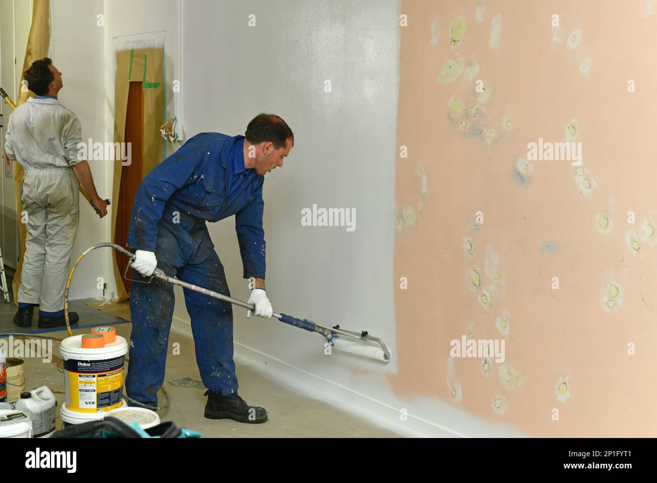 Greymouth, New Zealand, January 26, 2023: A painter applies an acrylic primer coat to the interior walls of a renovation building near Greymouth, Sout Stock Photo