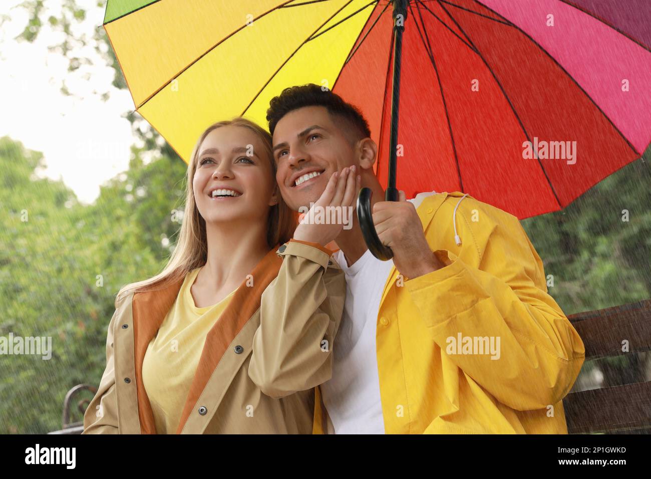 Lovely couple with umbrella under rain in park Stock Photo - Alamy