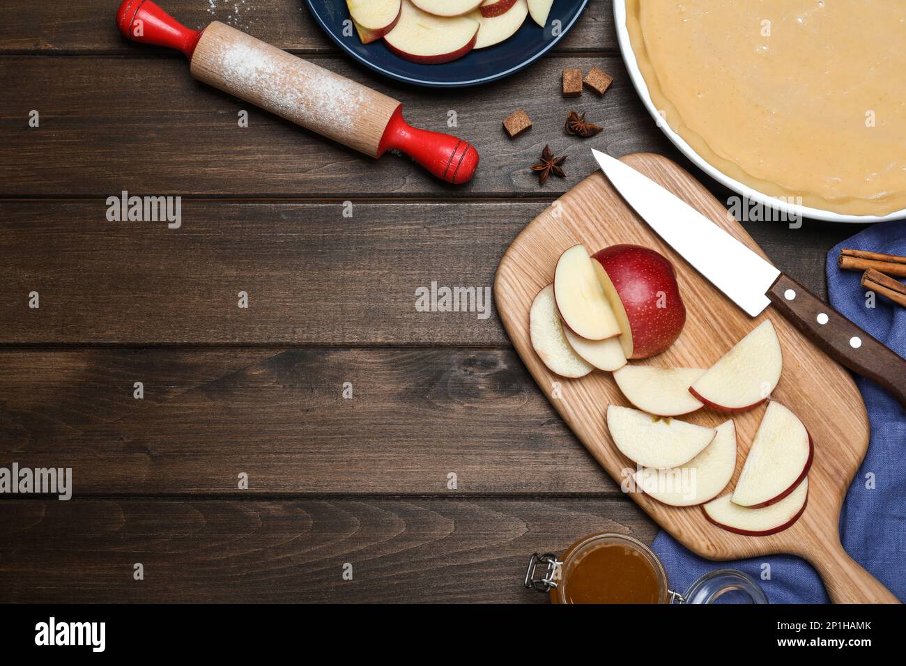 Cut fresh apple with knife, board on wooden table, flat lay and space for text. Baking pie Stock Photo