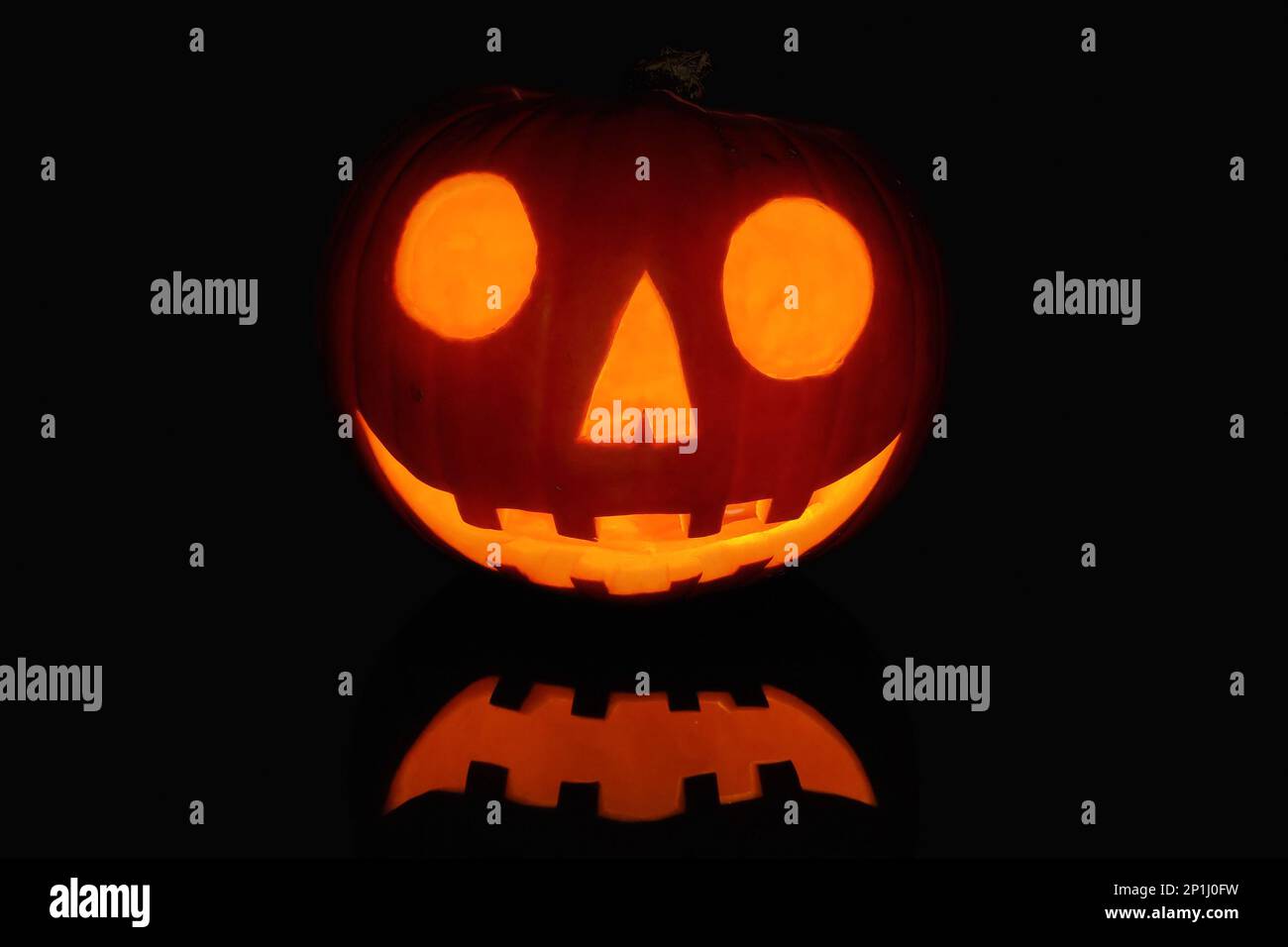 Jack O' Lantern reflecting on a black surface. Stock Photo