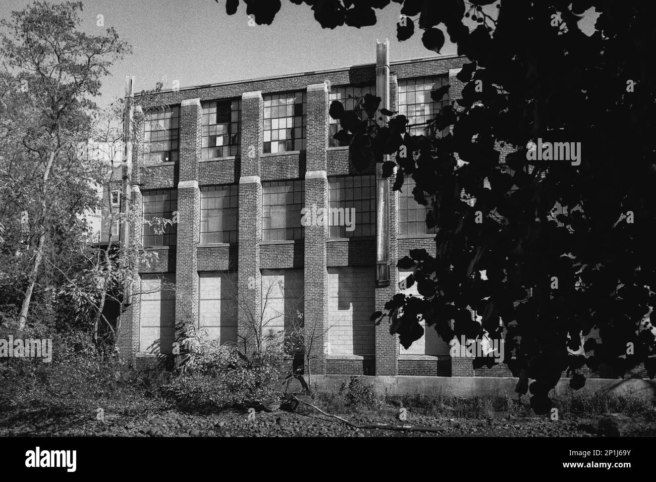 A weathered old factory standing next to the canal in Laconia, New
