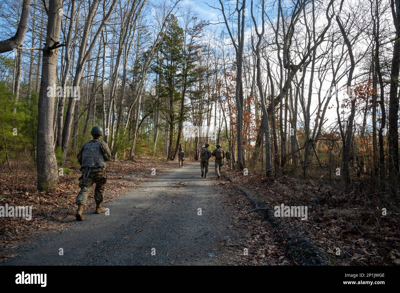 U.S. Air Force Outside the Wire pre-deployment training students in squad one move in a staggered formation from objective point one to objective point two to visit a simulated village during the final cumulative exercise, which encompasses all the skills they learned throughout OTW at Joint Base McGuire-Dix-Lakehurst, New Jersey, Feb. 10, 2023. OTW places students in realistic and strenuous training scenarios used to teach skills such as weapons control, combative techniques, communications, mounted and dismounted movements and land navigation. Stock Photo