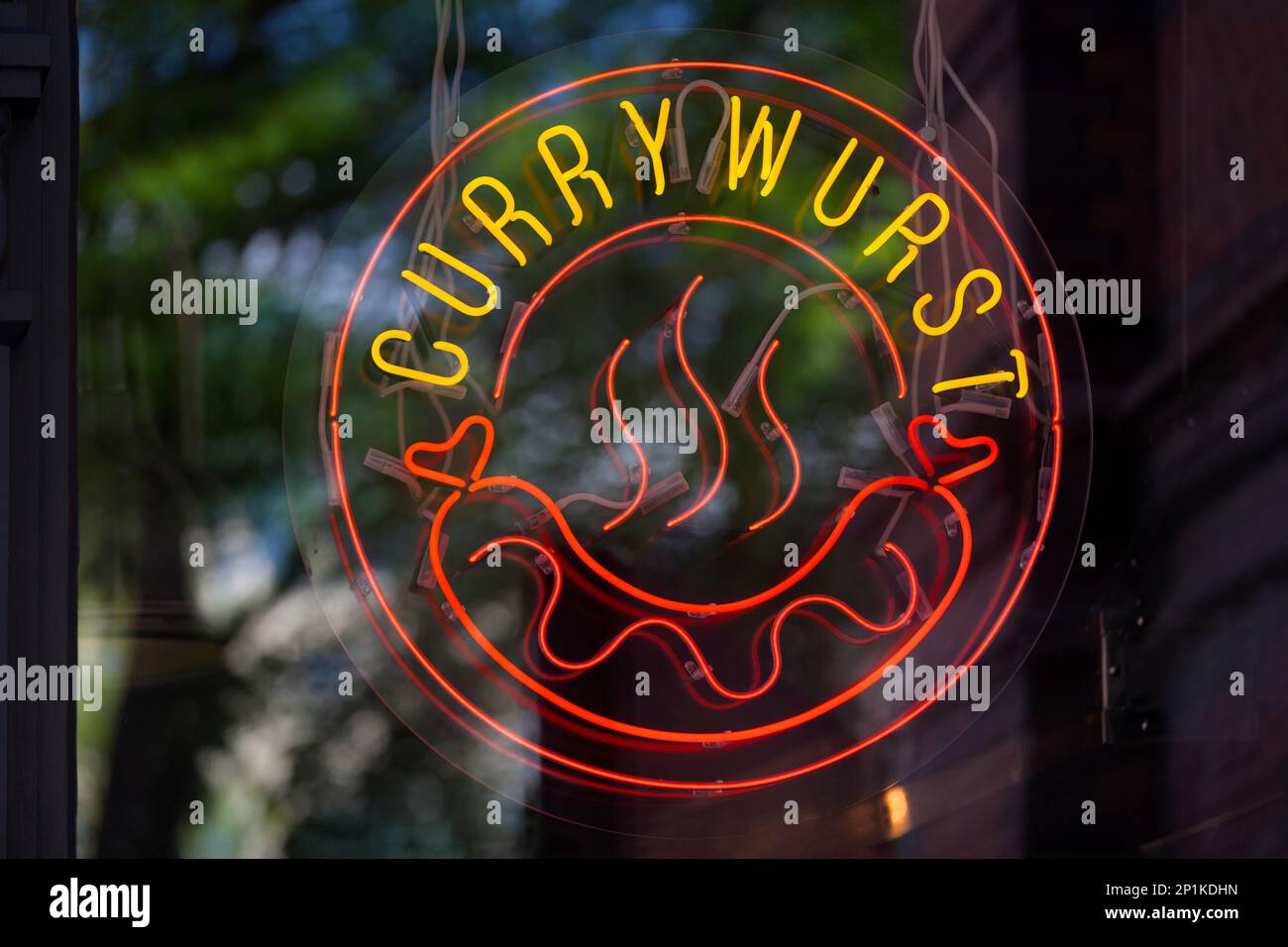 Circular neon light at a restaurant's window showing a Curry wurst ...