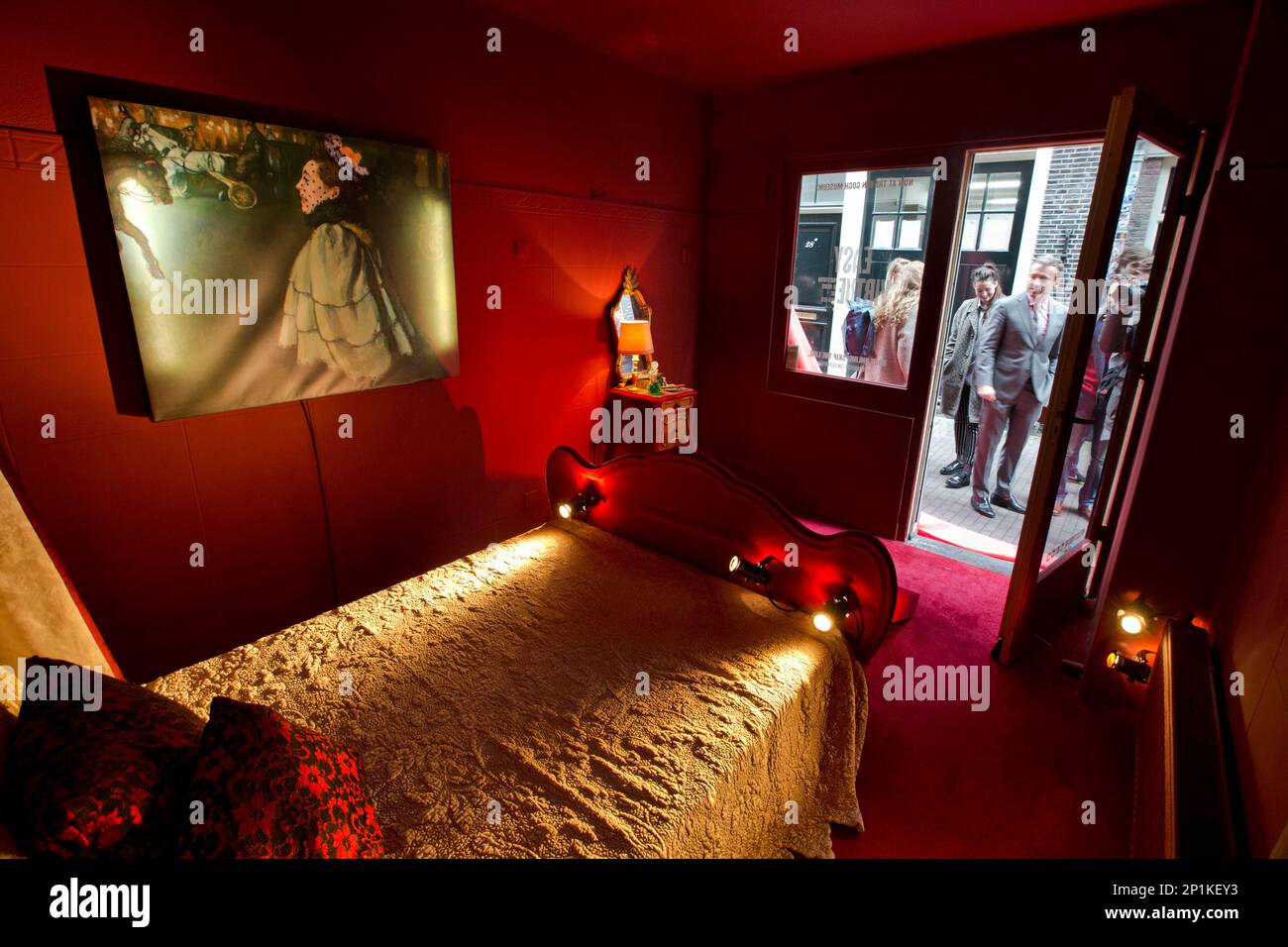 A copy of the painting titled Woman at the Champs-Elysees by Night by Louis Anquetin, left, is seen in a brothel setting in the Red Light District, as museum director Axel Ruger