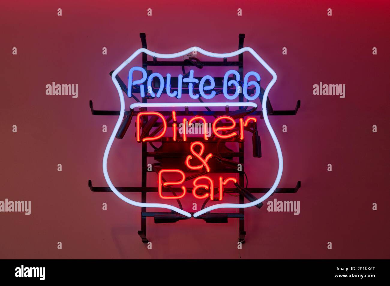 Close-up on a neon light shaped into a route 66 sign with written in it 'Diner & Bar'. Stock Photo