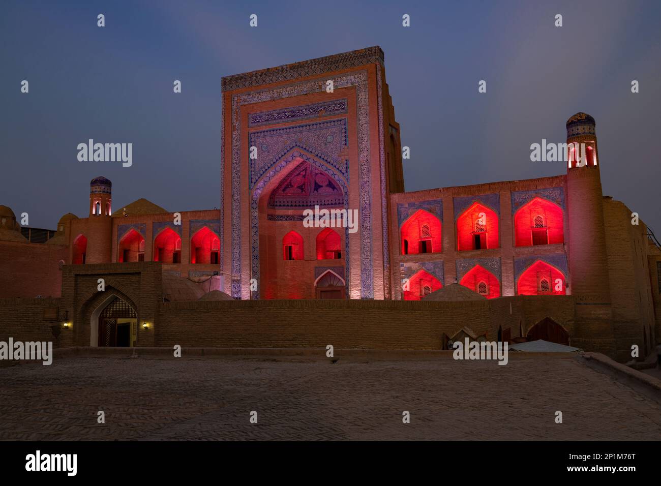KHIVA, UZBEKISTAN - SEPTEMBER 07, 2022: Ancient madrasah of Allakuli Khan in red night illumination on a evening twilight Stock Photo