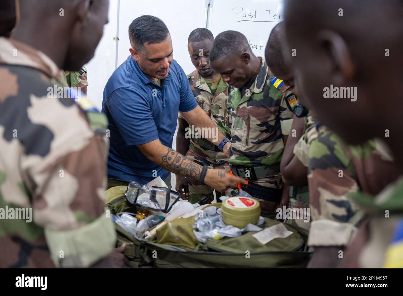 U.S. Army Sgt. Antonio Cruz Hernandez (left), 443rd Civil Affairs  Battalion, demonstrates the use of a pelvic sling, used in the  stabilization of pelvic fractures, with members of the Niger Armed Forces (