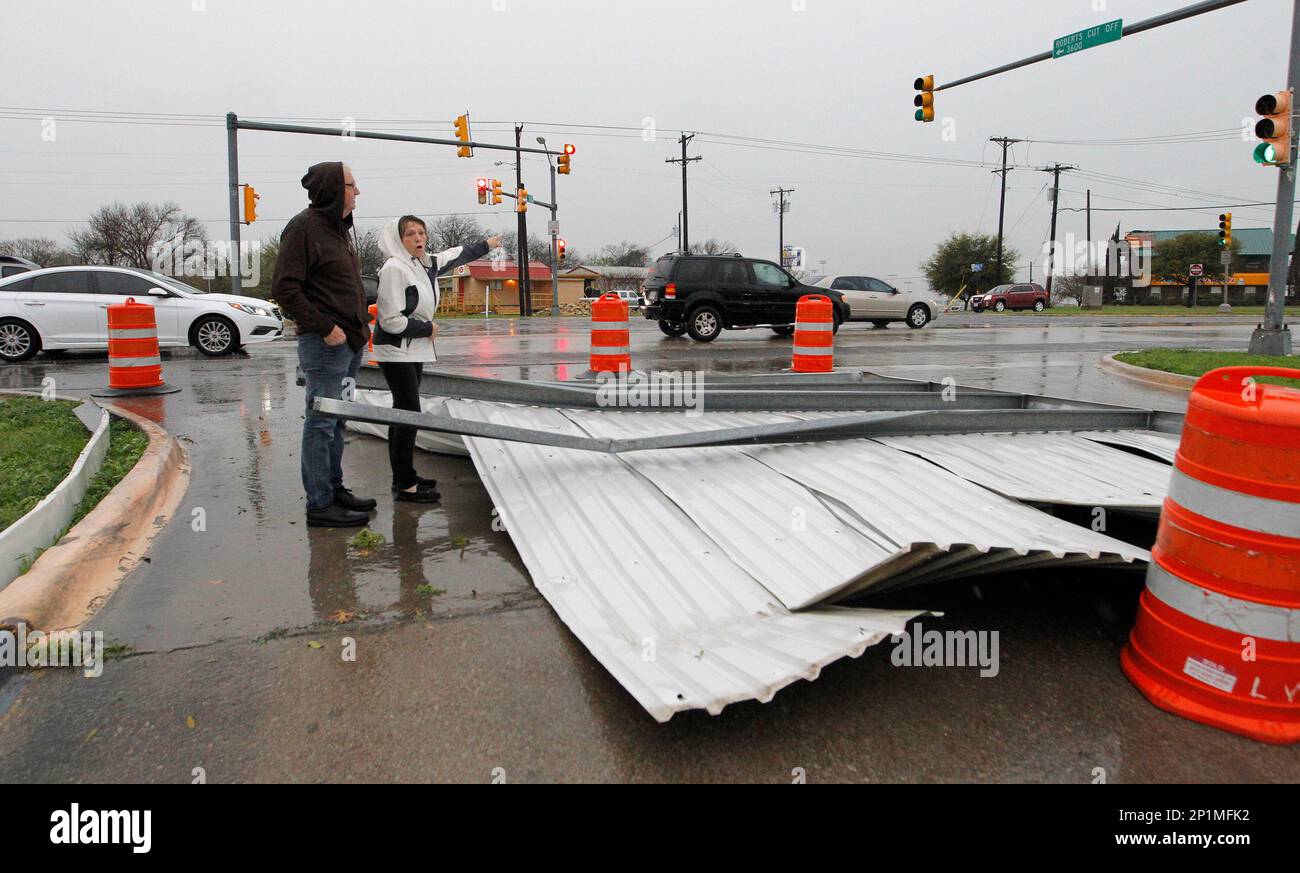 Dusty Young and Diane Barnes look storm damage in Sansom Park, Texas as
