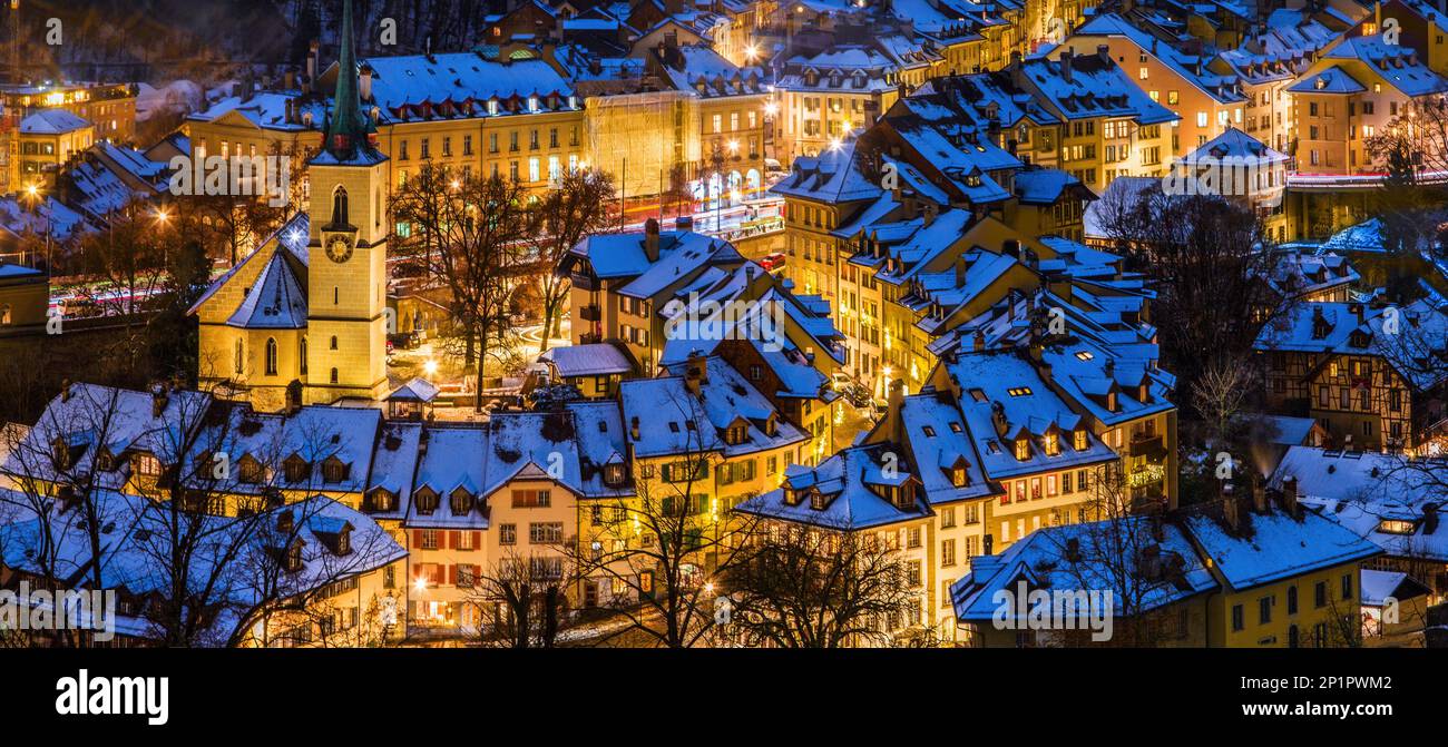 Alleys and lanes of the town center of Bern in winter blue hour with snow-covered roofs and illuminated buildings in Christmas season, Rosengarten, Be Stock Photo