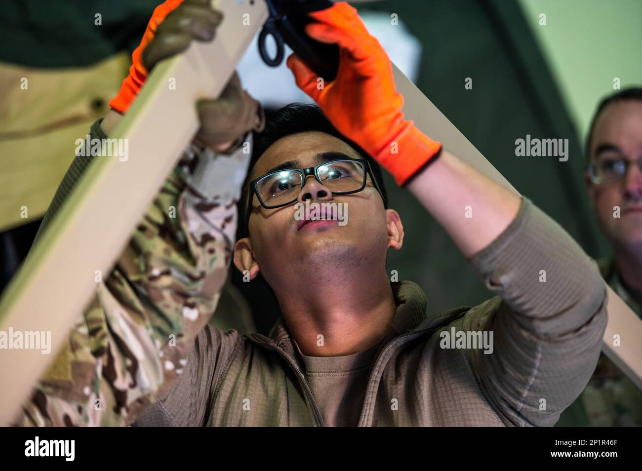 U.S. Air Force Staff Sgt. Kiven Alfelor, 51st Medical Support Squadron war reserve material maintenance craftsman, adjusts the frame coupling of a Tent Kit 2 (TK2) expeditionary medical support shelter during a training event at Osan Air Base, Republic of Korea, Jan. 12, 2023. The TK2 allows personnel to operate without mission oriented protective posture (MOPP) gear while inside, allowing freedom of movement and unfettered communication in a hazardous environment. Stock Photo