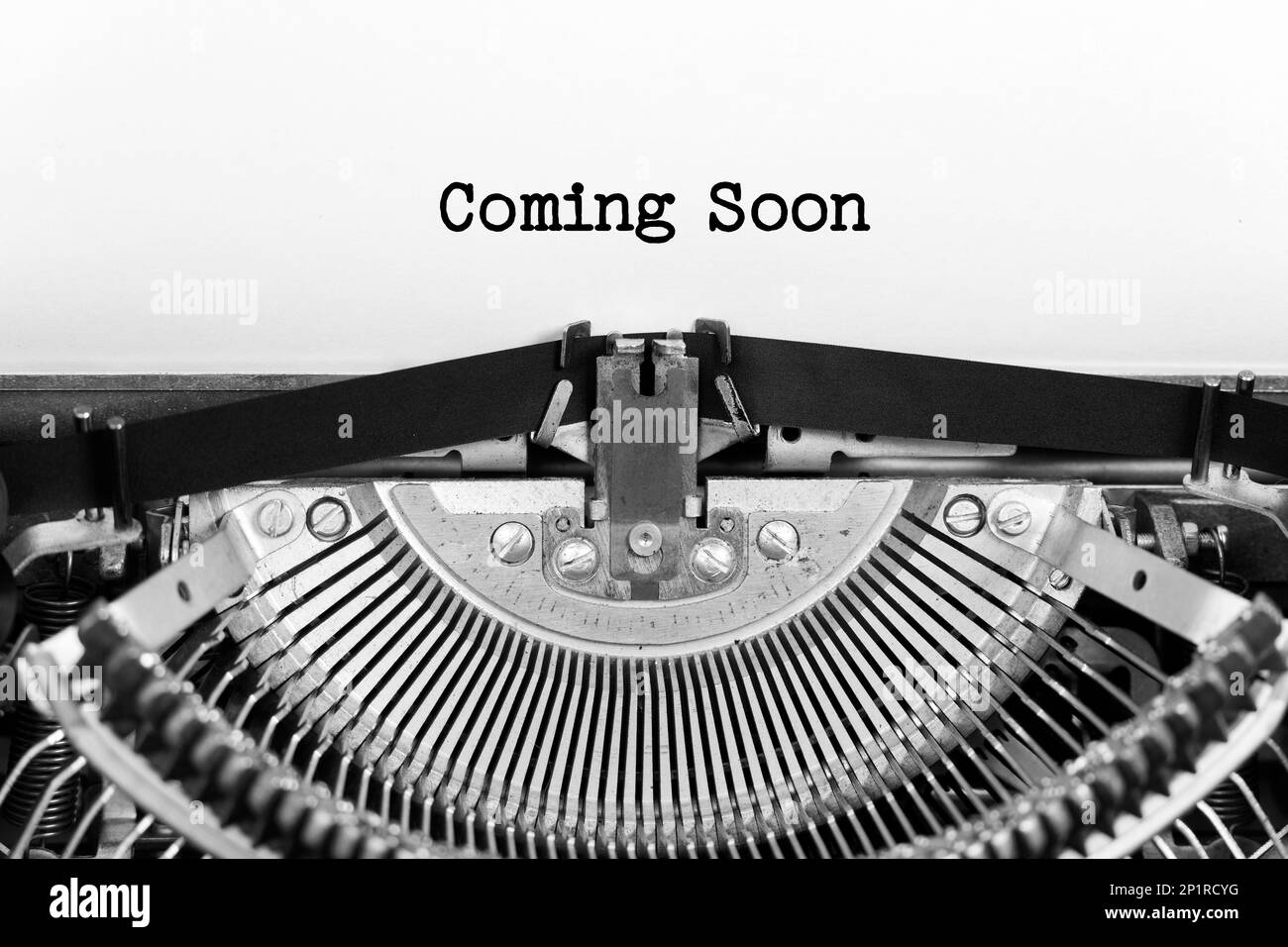 Coming Soon phrase close up being typing and centered on a sheet of paper on old vintage typewriter mechanical Stock Photo