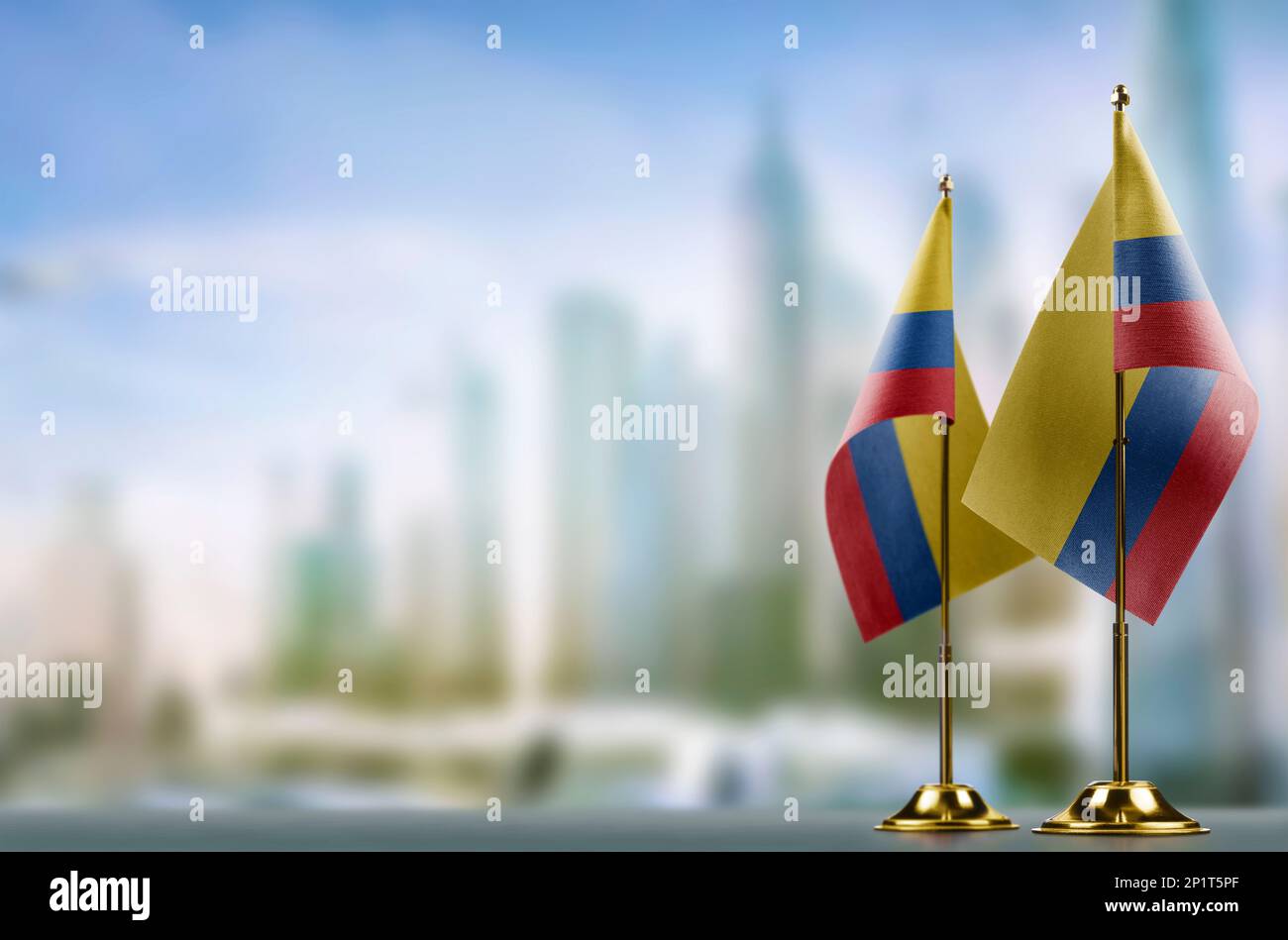 Small flags of the Colombia on an abstract blurry background. Stock Photo