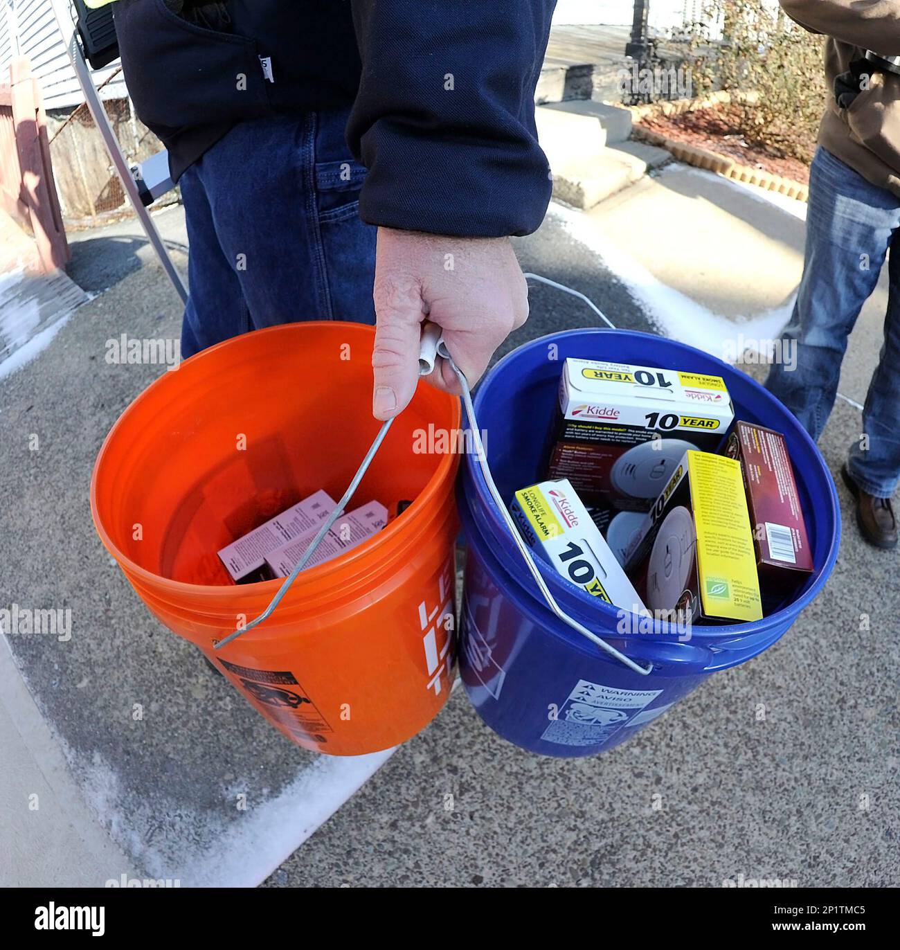 Mike Yanchuk, an employee of UGI, carries buckets of smoke alarms to