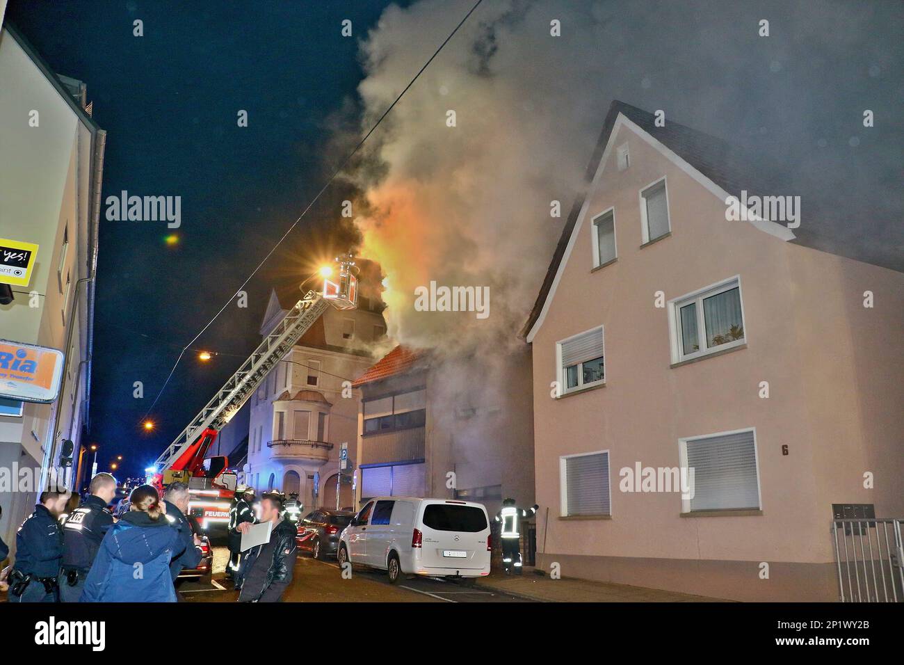 Stuttgart, Germany. 04th Mar, 2023. Emergency personnel stand in front of a residential building during firefighting operations while firefighters extinguish a roof truss fire. According to initial estimates, around 700,000 euros in damage was caused by an attic fire. Rescue workers took a 93-year-old resident of the attic apartment to hospital with smoke inhalation, according to a police spokesman. Credit: Karsten Schmalz/KS-Images.de/dpa/Alamy Live News Stock Photo