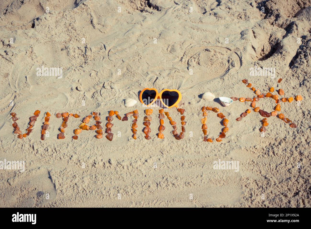Inscription vitamin D with shape of sun made of amber stones and