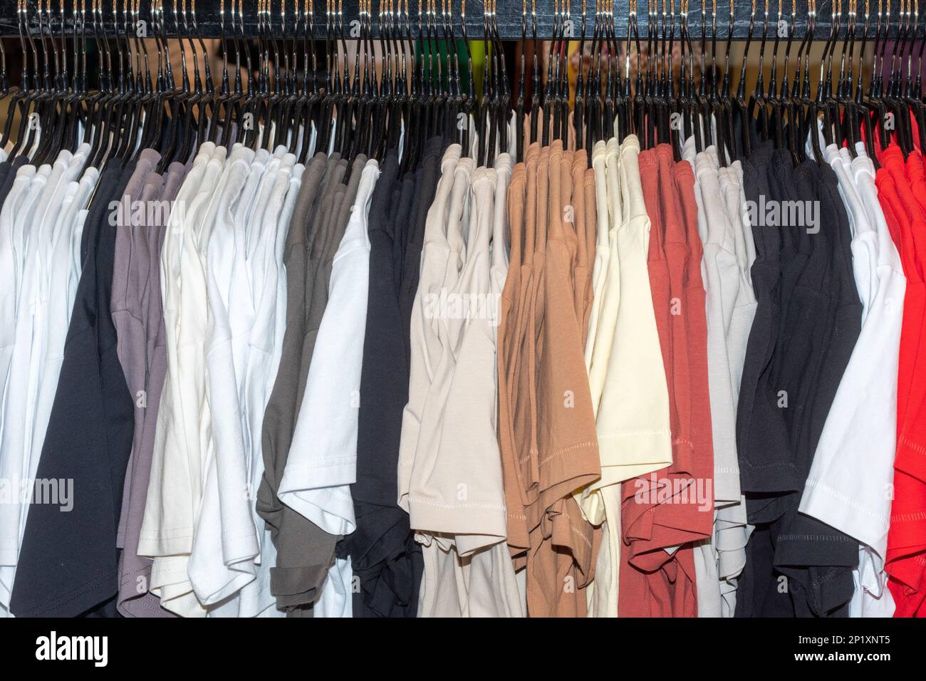 fashion clothing on hangers at the show. Fashionable bright colorful clothes in the wardrobe. the spring cleaning concept. autumn home wardrobe. Stock Photo