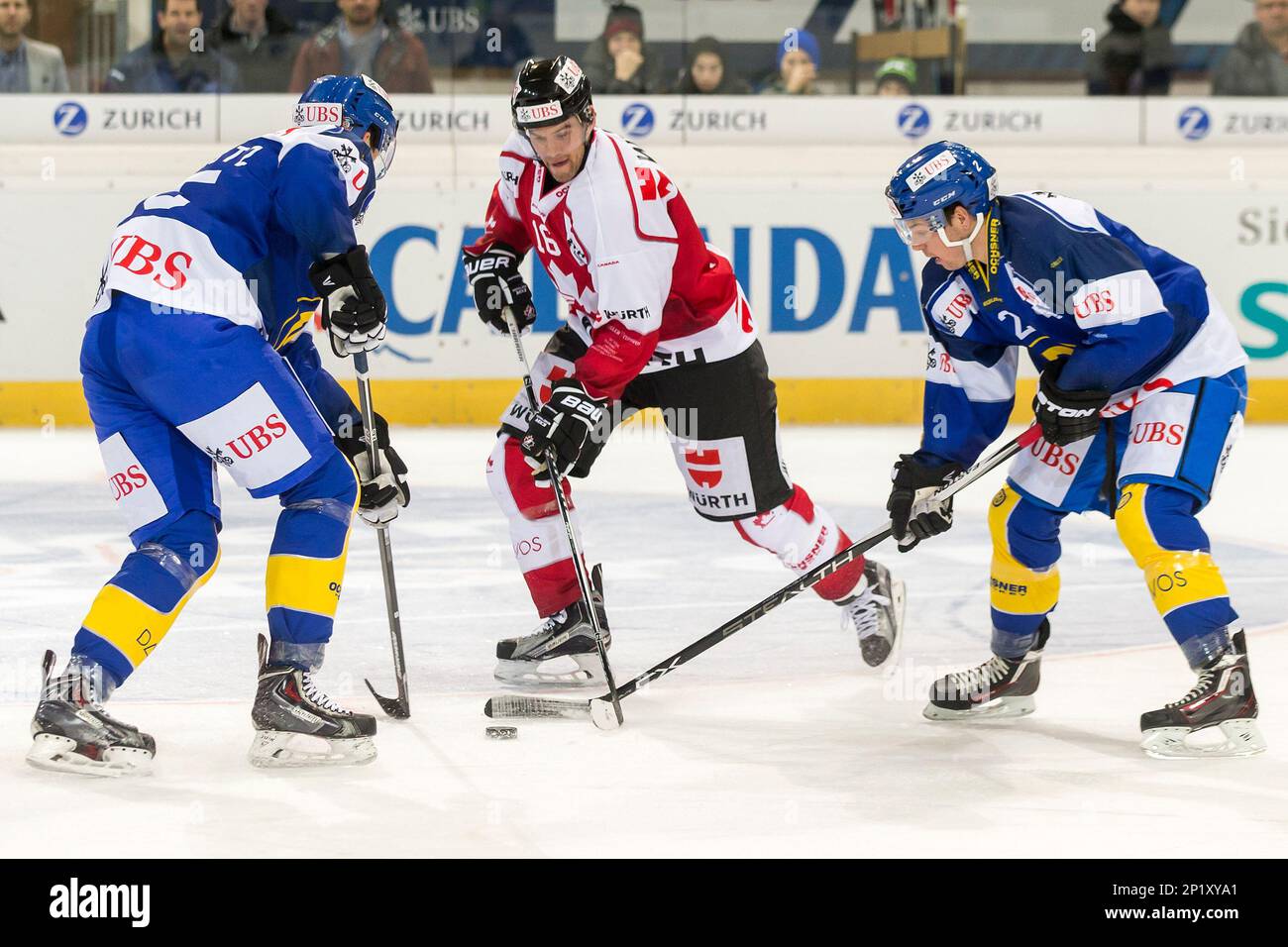 Davos' Silvio Schmutz, left, and Jens Nater, right, challenge for the puck  with Team Canada's Daniel Paille during the match between Switzerland's HC  Davos and Team Canada at the 89th Spengler Cup