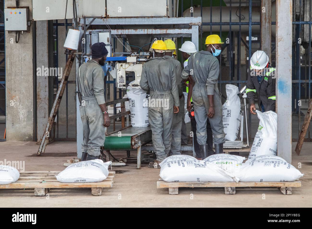 Workers operate a fertilizer packaging unit at the Fertiplant