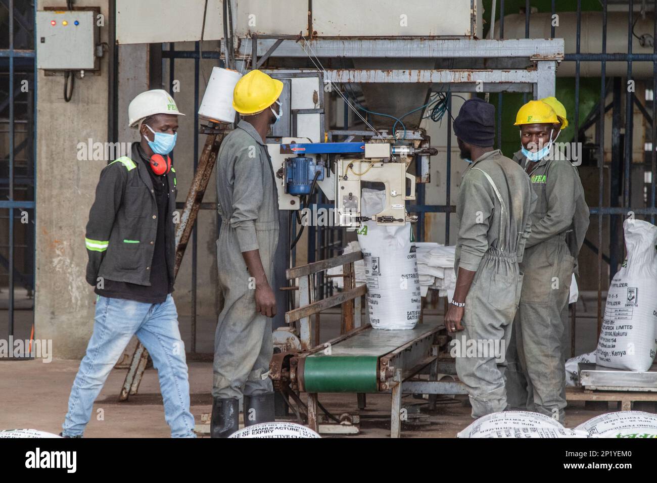 Workers operate a fertilizer packaging unit at the Fertiplant