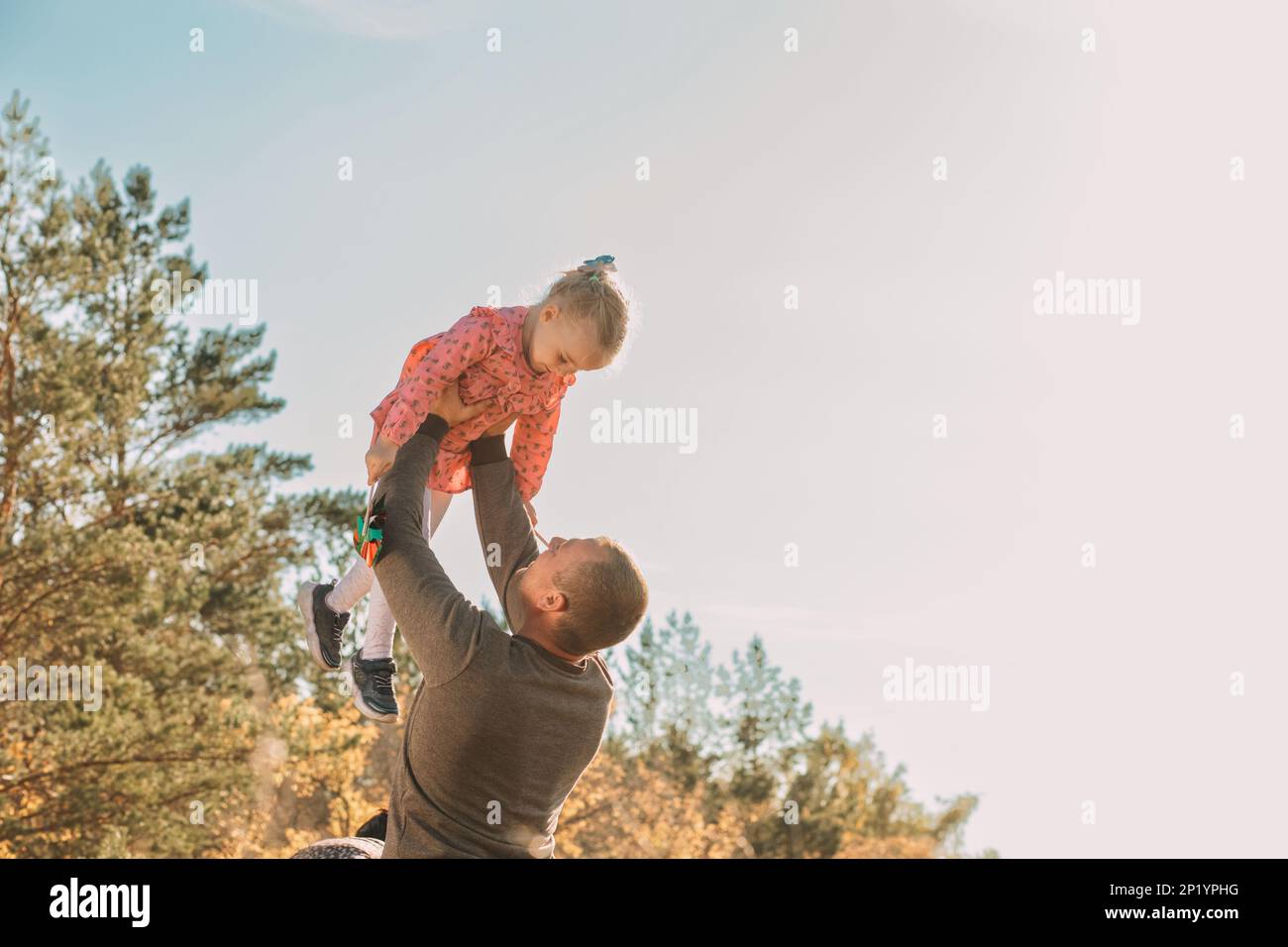 Family holiday. Father and daughter happily. Father carried his daughter and lifted him up into the sky. daughter acted with arms outstretched to fly Stock Photo