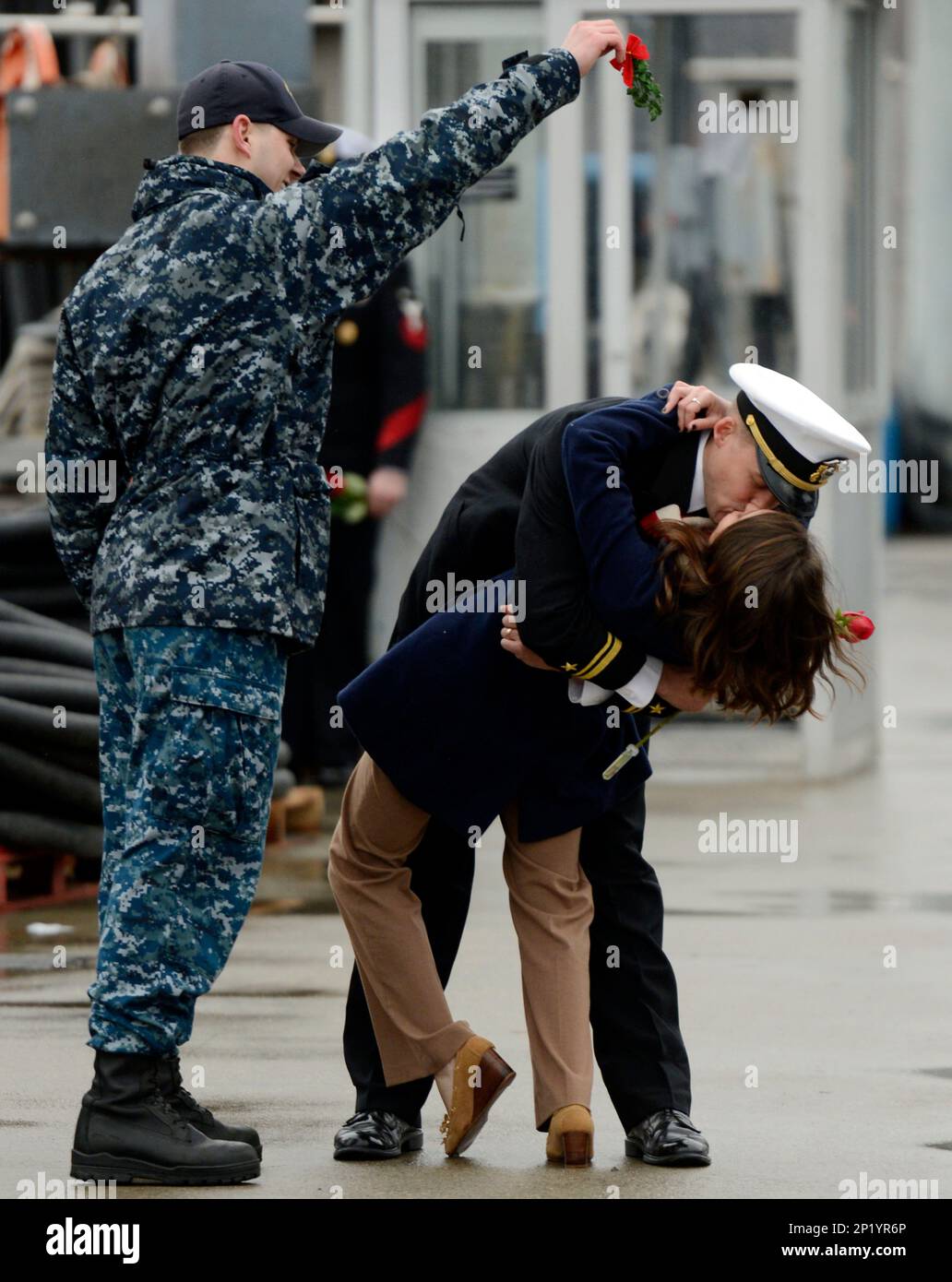 U.S. Navy Lt. jg. Stephen Bogdanowicz, left, holds a sprig of mistletoe ...