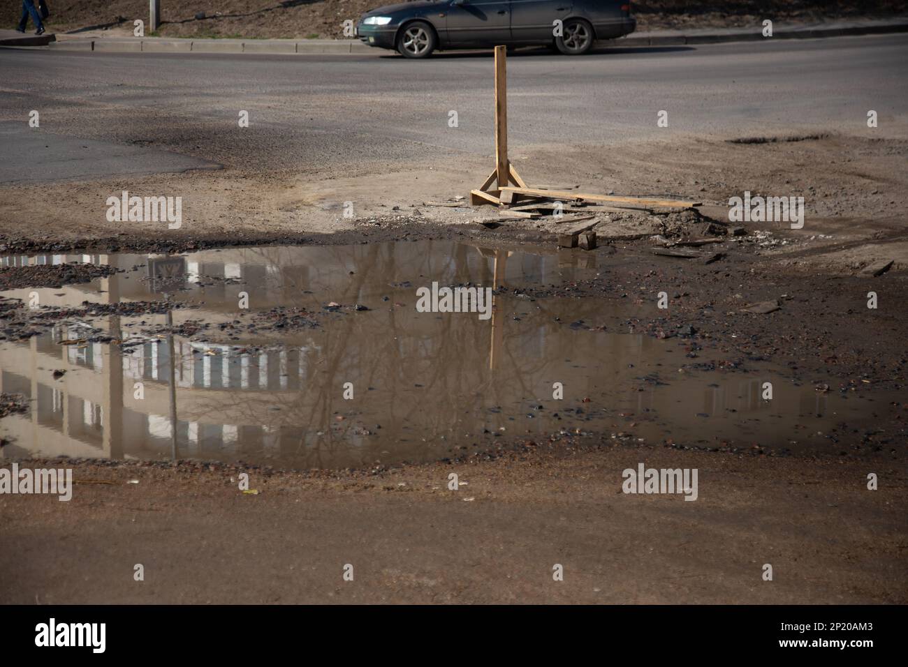 Due to the violation of road construction technology, severe frosts and heavy rains, the asphalt washed out the road and numerous cracks formed Stock Photo