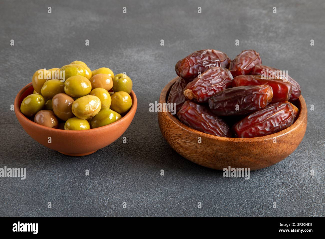 Date fruit with green olives on dark background Stock Photo