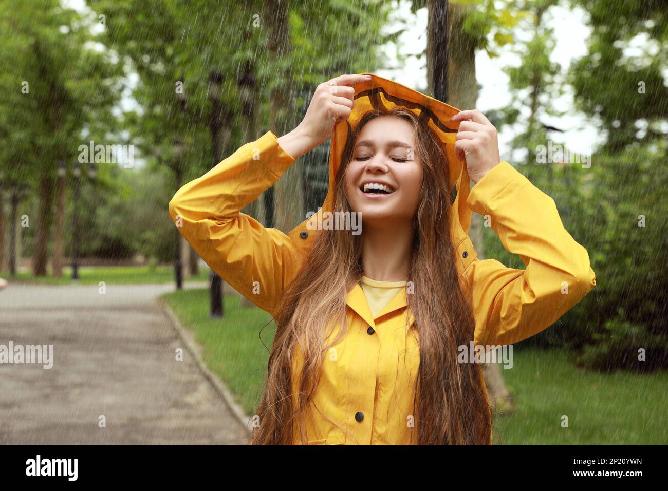 Woman wearing yellow raincoat hi-res stock photography and images - Alamy