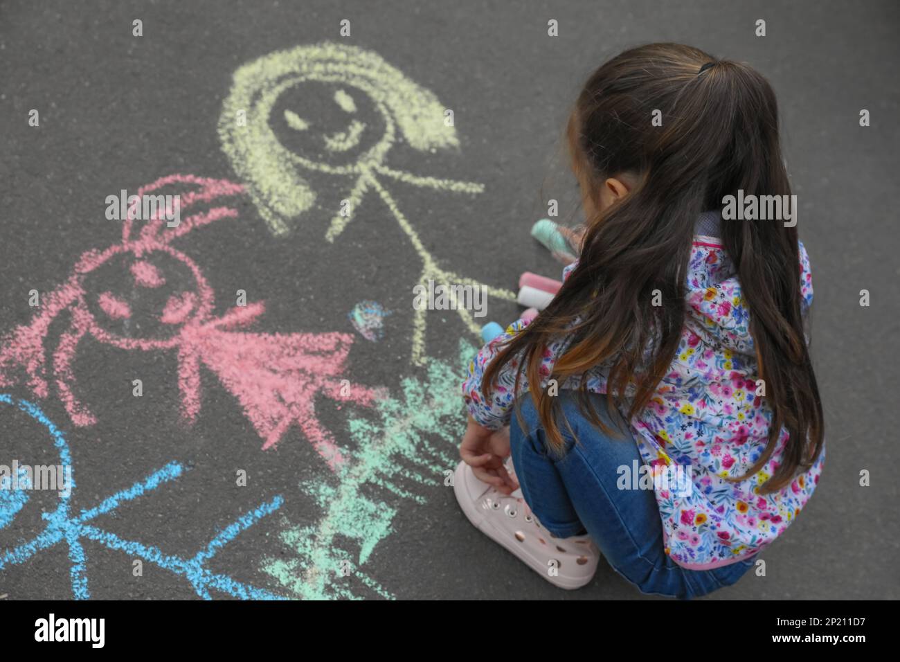 Child drawing family with chalk on asphalt Stock Photo - Alamy