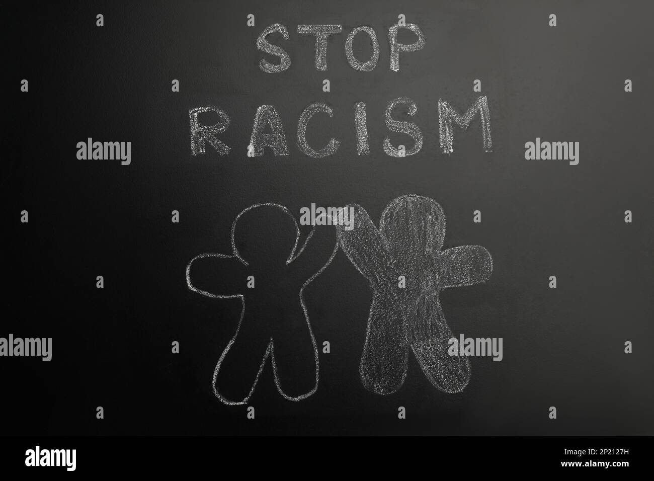 Chalked inscription Stop Racism and people figures on blackboard Stock Photo