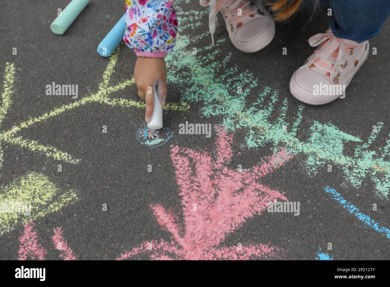 Child drawing family with chalk on asphalt, closeup Stock Photo - Alamy