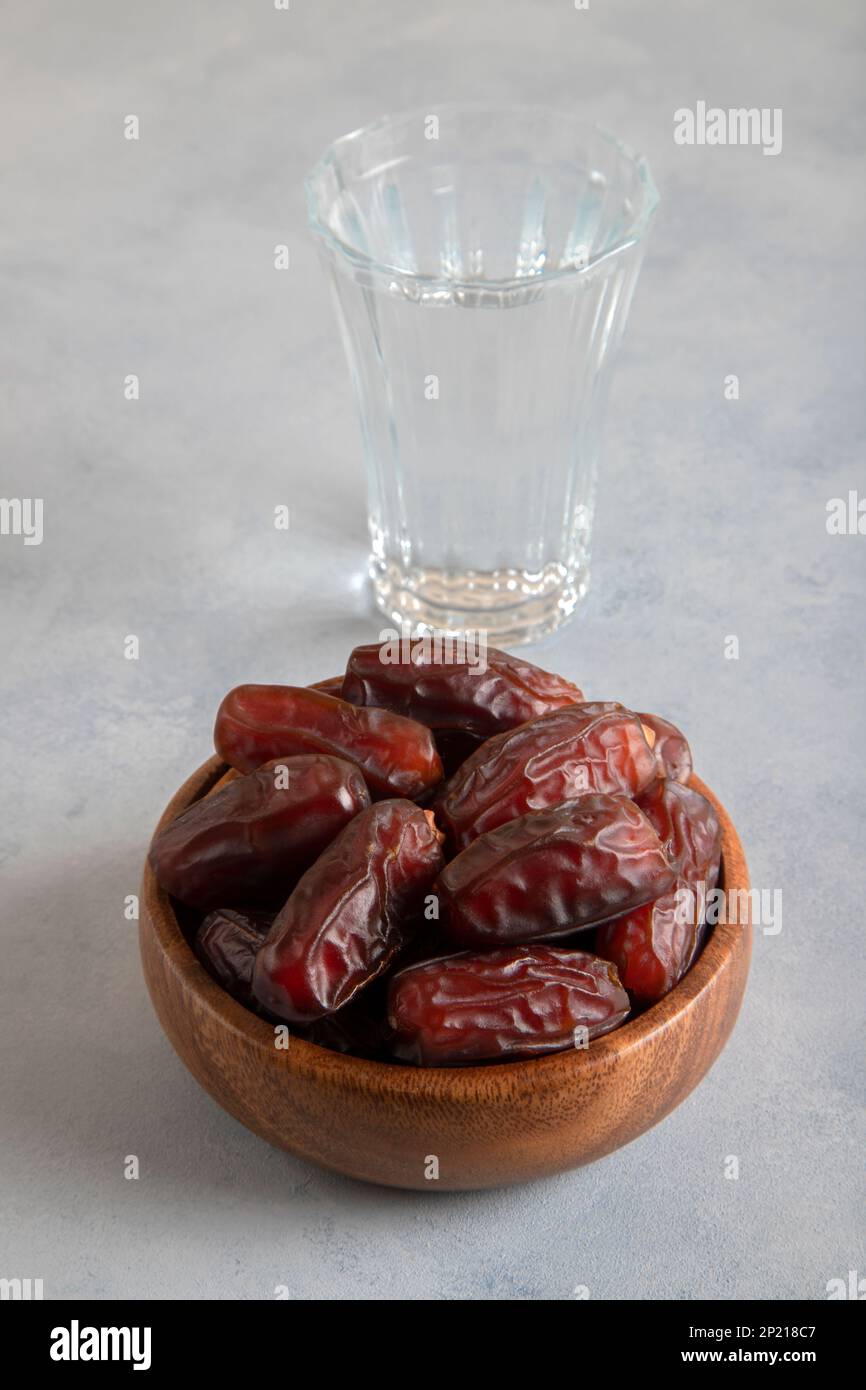Glass of water with a bowl of date fruit,on bright background Stock Photo