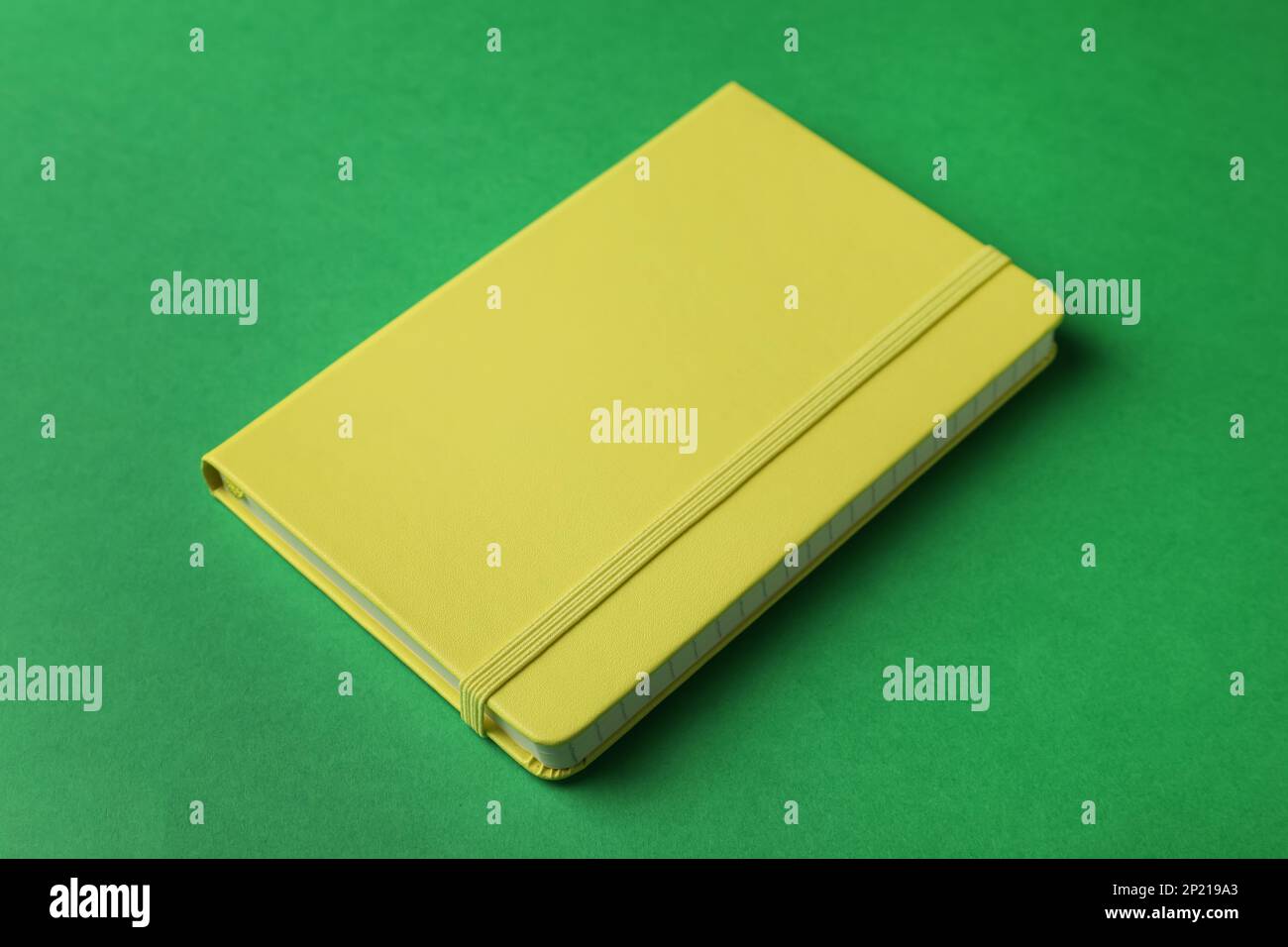 New stylish planner with hard cover on green background Stock Photo