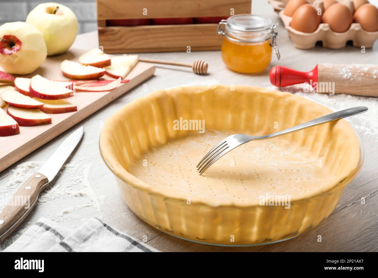 Raw dough with fork and ingredients on white wooden table. Baking apple pie Stock Photo
