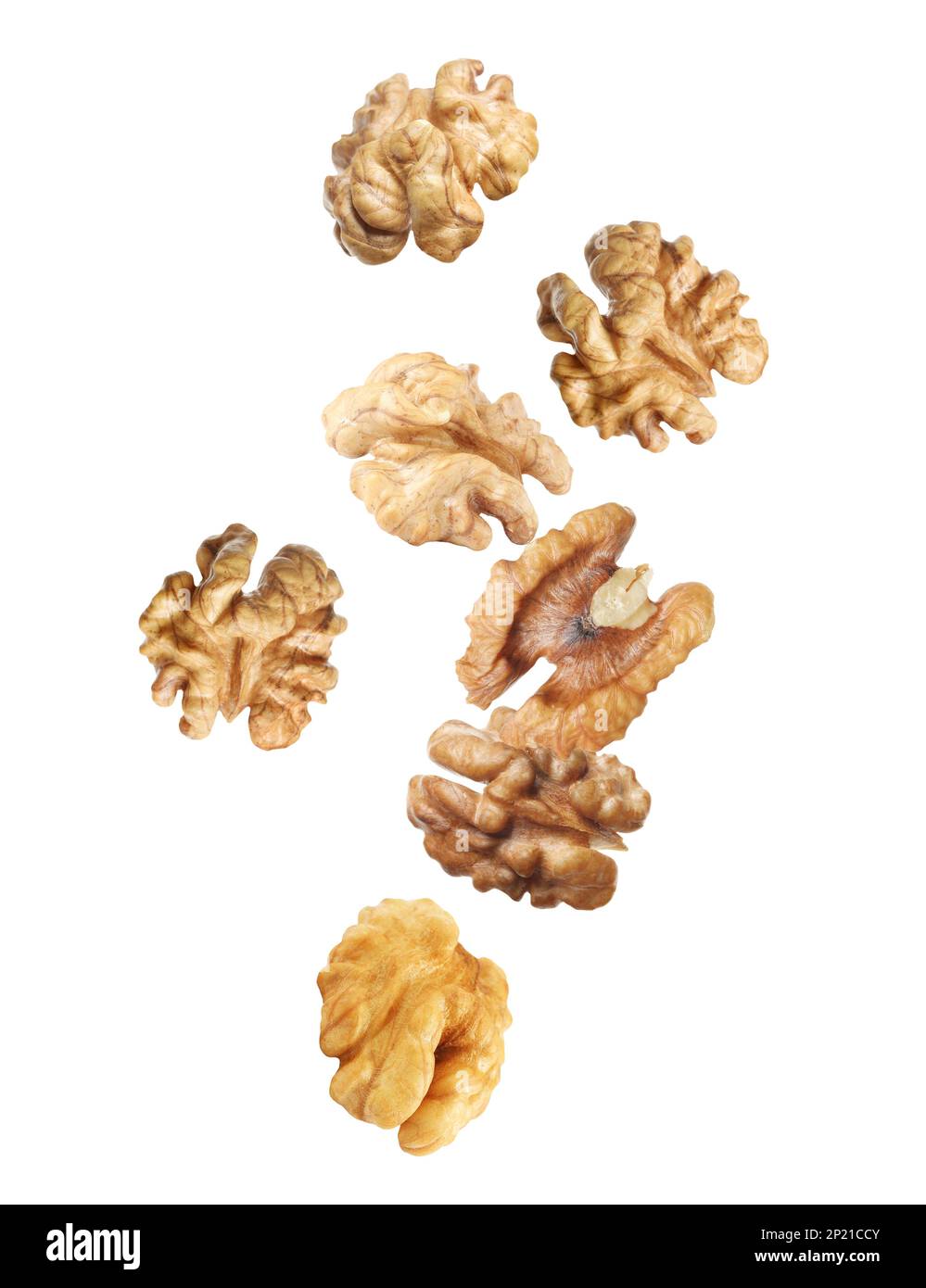 Halves of walnuts falling on white background Stock Photo - Alamy