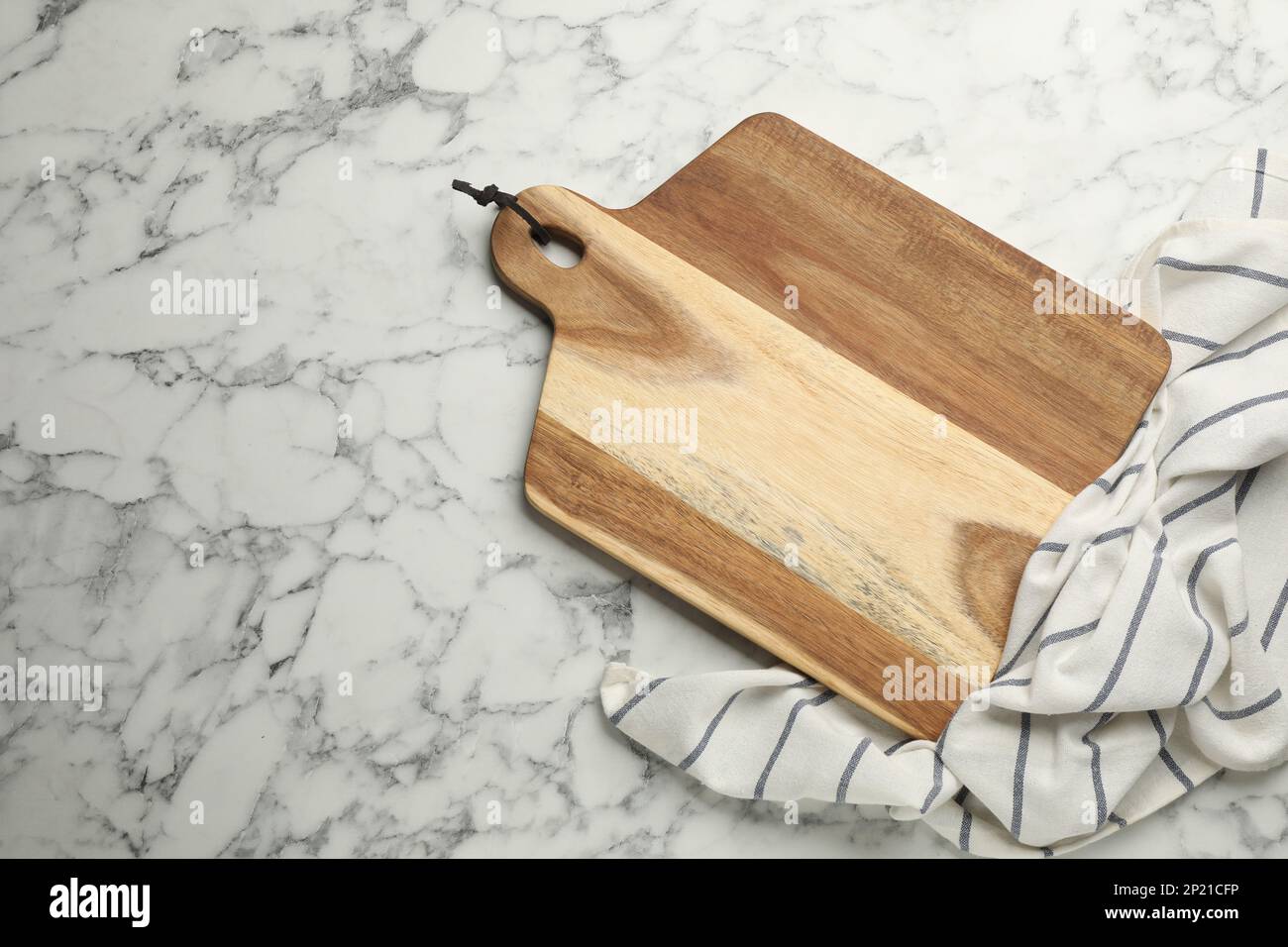 https://c8.alamy.com/comp/2P21CFP/wooden-cutting-board-and-kitchen-towel-on-white-marble-table-flat-lay-with-space-for-text-cooking-utensil-2P21CFP.jpg