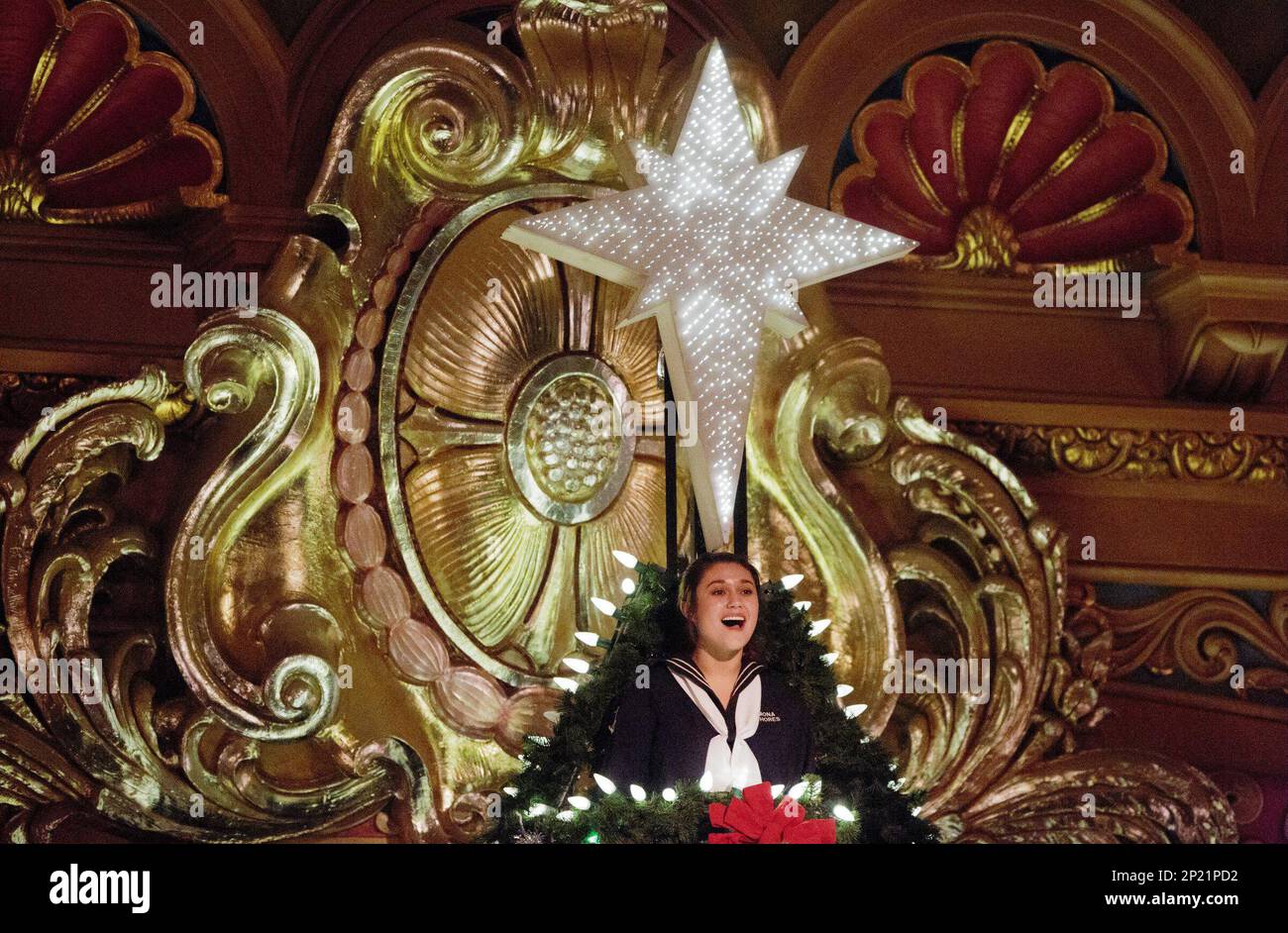 Mona Shores "angel" Madison Strait sings from the top of the Christmas tree during the annual