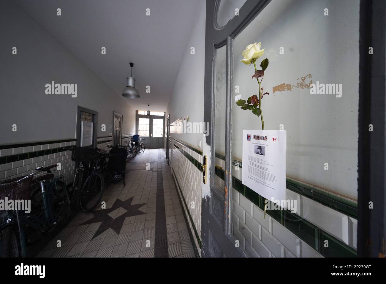 Berlin, Germany. 04th Mar, 2023. The front door of the address Käthe-Niederkirchner-Strasse 23 is decorated with a flower during a memorial service for the rubber manufacturer Julius Fromm. Fromm, who was born in Konin, Poland, in 1883 and died in 1945, lived at this address and invented the first seamless contraceptive here. Credit: Joerg Carstensen/dpa/Alamy Live News Stock Photo