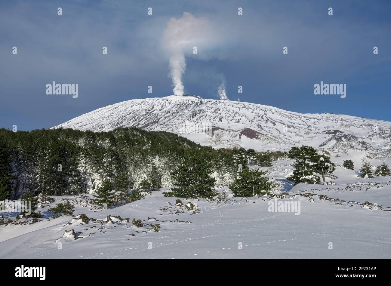 covered in snow Mount Etna volcano eruption from summit craters in
