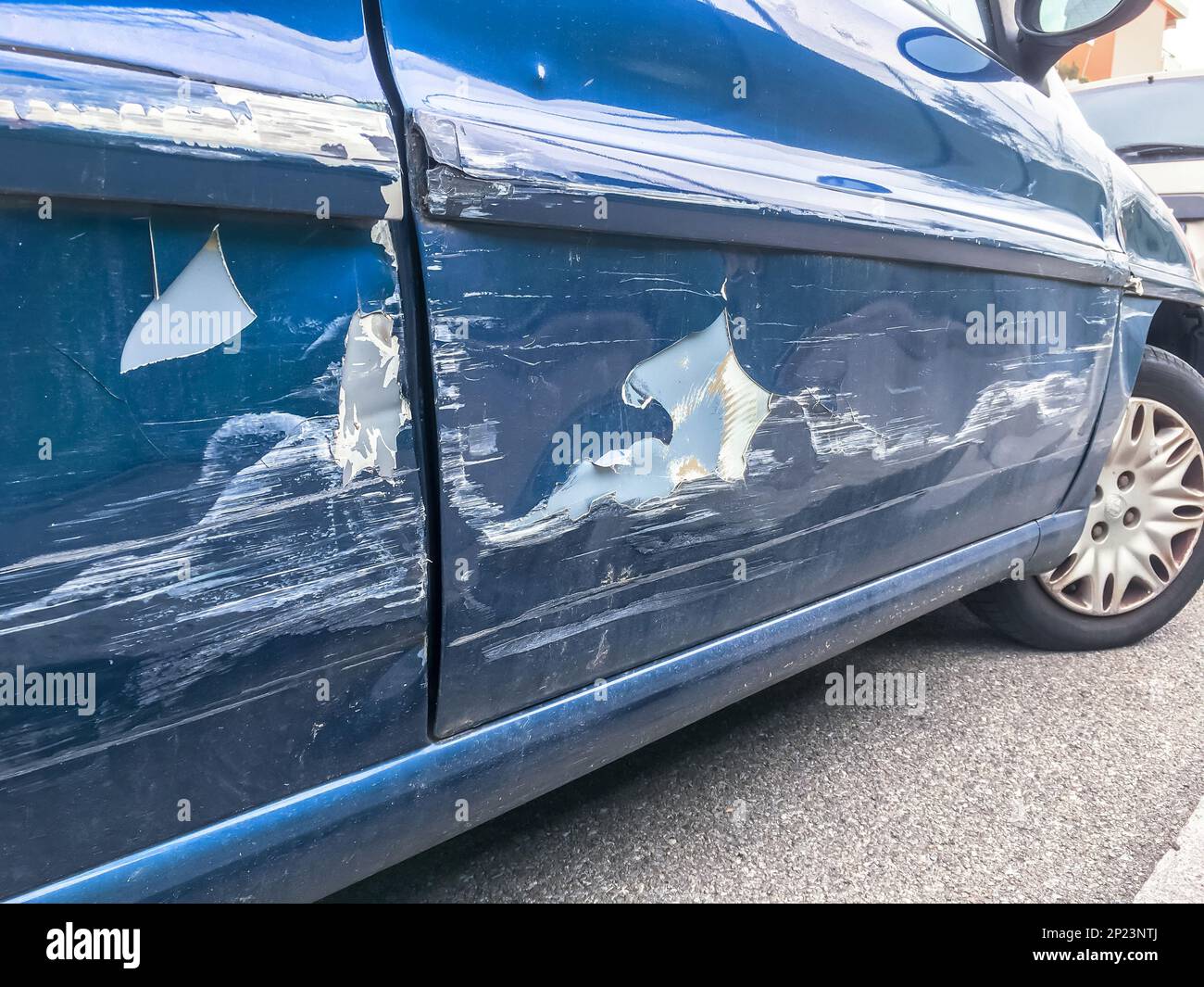 Blue car with a dent in the side of the car in the street after an accident Stock Photo