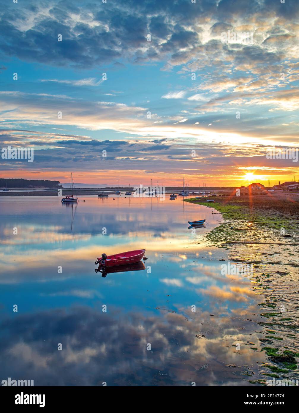 Summer sunset with colourful skies, moored yachts and boats at Findhorn harbour on the Moray coast in Scotland, United Kingdom Stock Photo