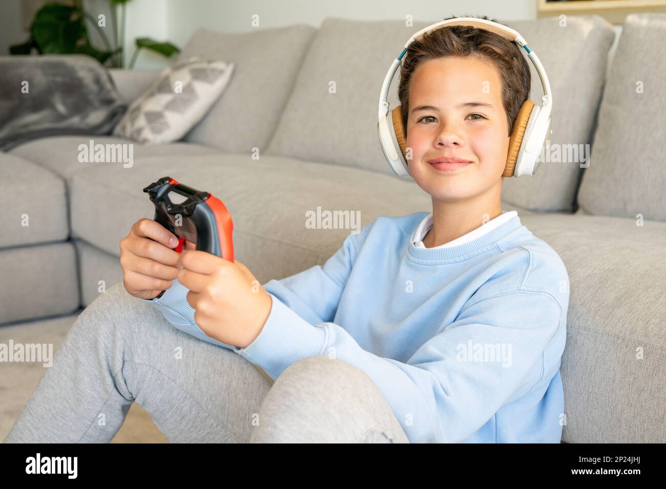 Shot of an adorable young boy wearing headphones while playing video