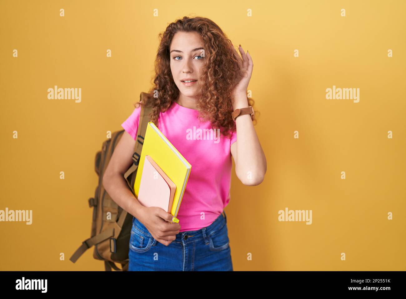 Young caucasian woman wearing student backpack and holding books ...