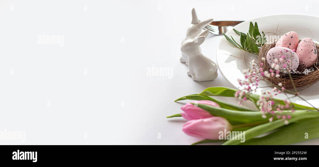 Easter background with colored Easter eggs and blooming flowers, tulips. Two Easter Bunnies. Easter composition. Easter. Banner. copy space Stock Photo