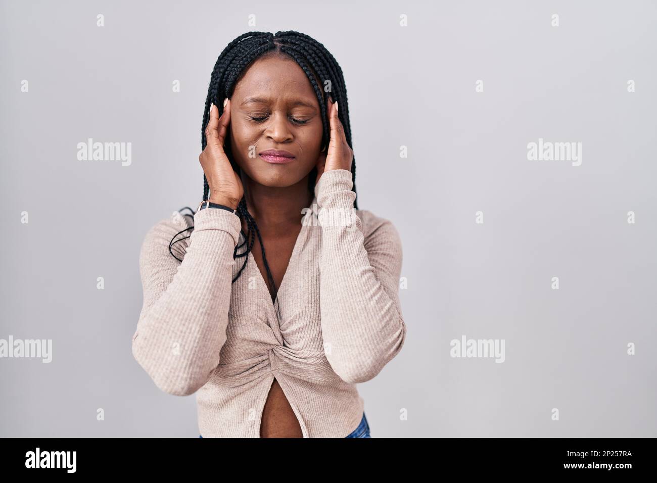 African woman with braids standing over white background with hand on
